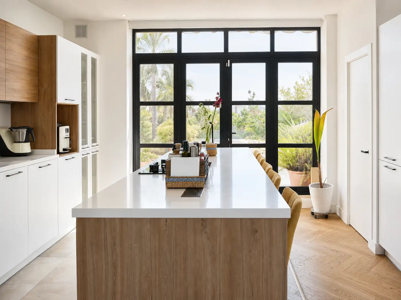 Cocina reformada con isla y grandes ventanales al jardín